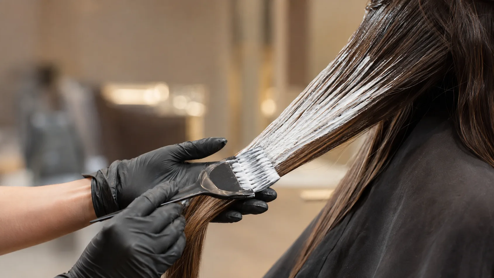 Freihändiger Balayage-Auftrag mit Pinsel an einer langen Haarsträhne